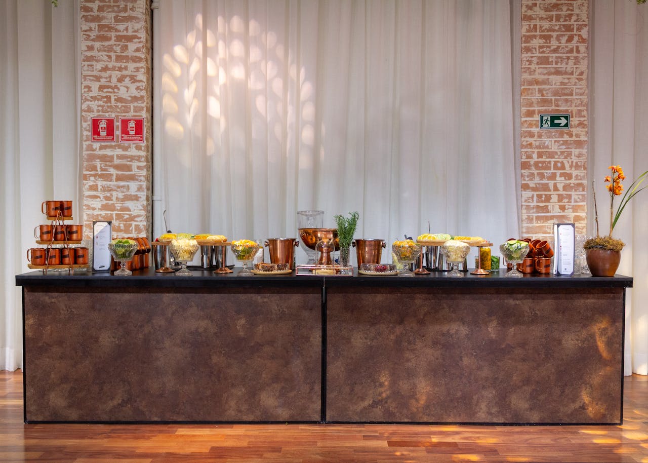 Stylish buffet table arrangement with copper accents and floral decor in a modern indoor setting.