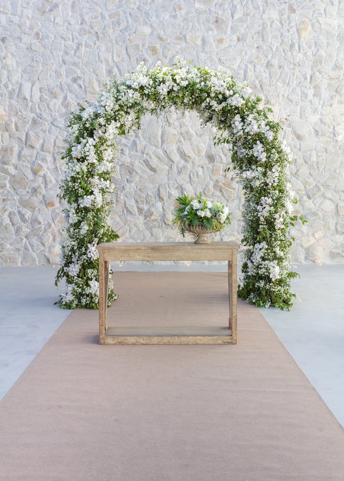 Beautiful white floral arch and table decoration for a wedding ceremony in São Paulo.